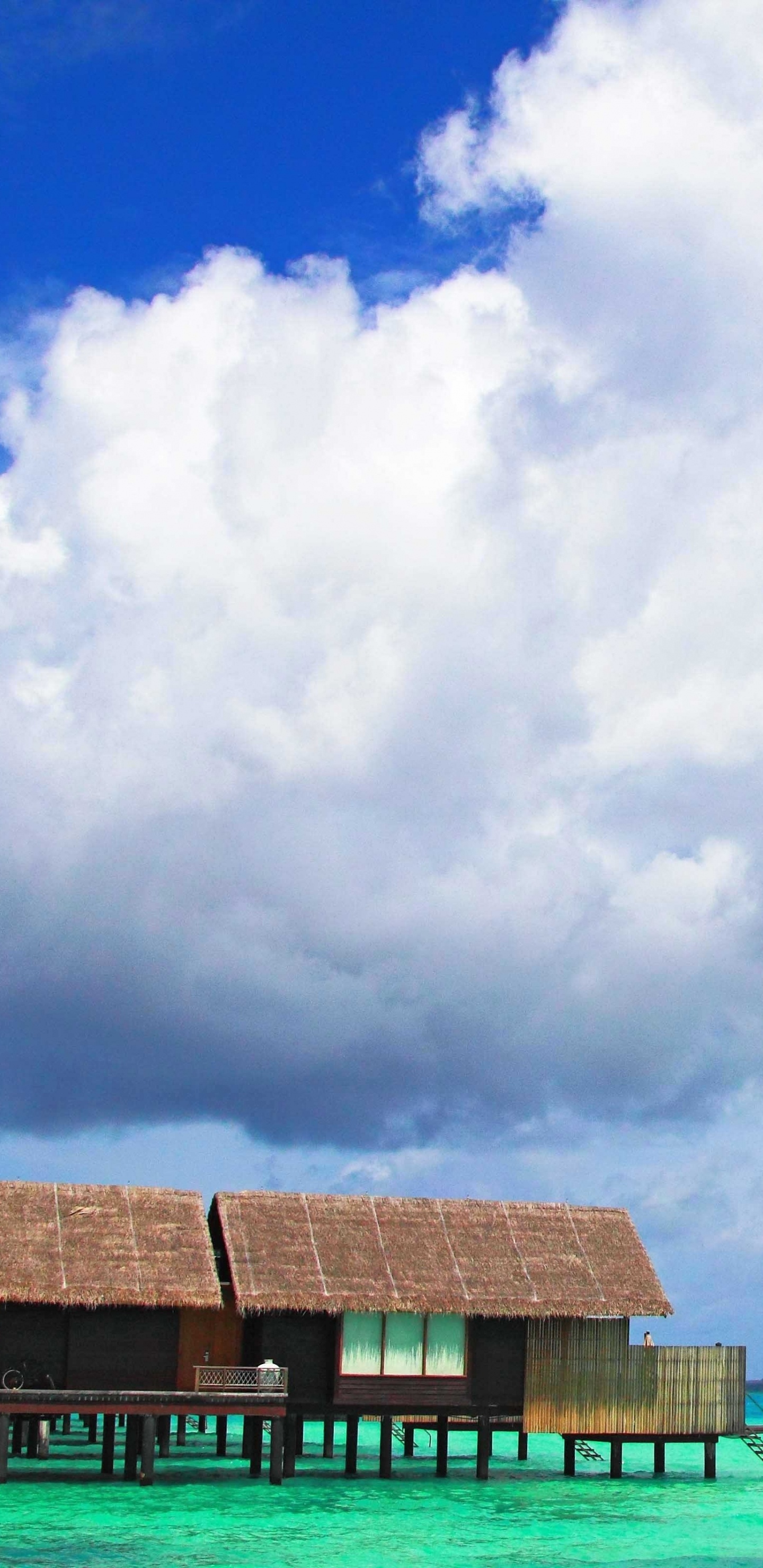 Braunes Holzhaus am Meer Unter Weißen Wolken Und Blauem Himmel Tagsüber During. Wallpaper in 1440x2960 Resolution