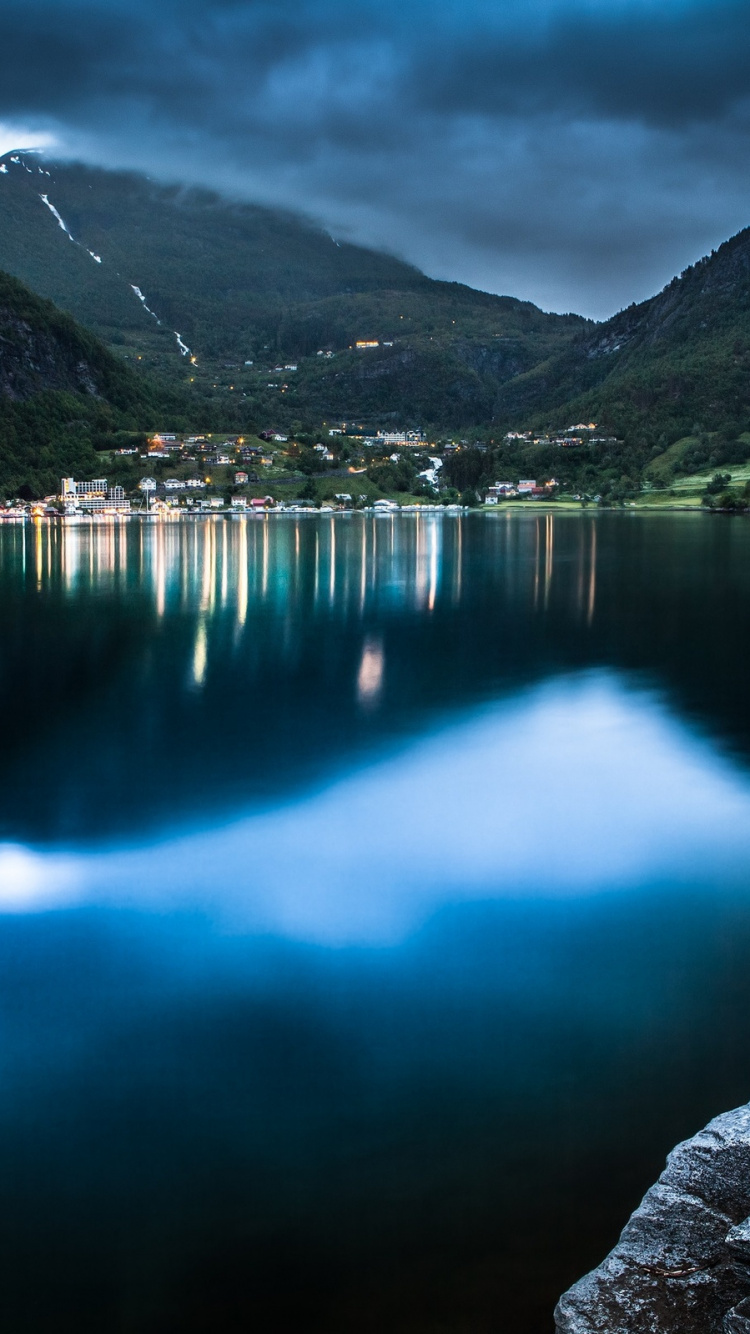 Personne en Sweat à Capuche Rose Assis Sur un Rocher Près du Lac Pendant la Journée. Wallpaper in 750x1334 Resolution