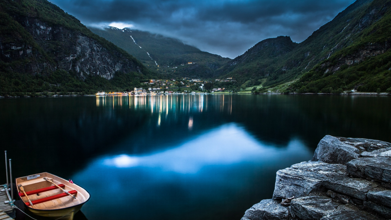 Person in Pink Hoodie Sitting on Rock Near Lake During Daytime. Wallpaper in 1366x768 Resolution