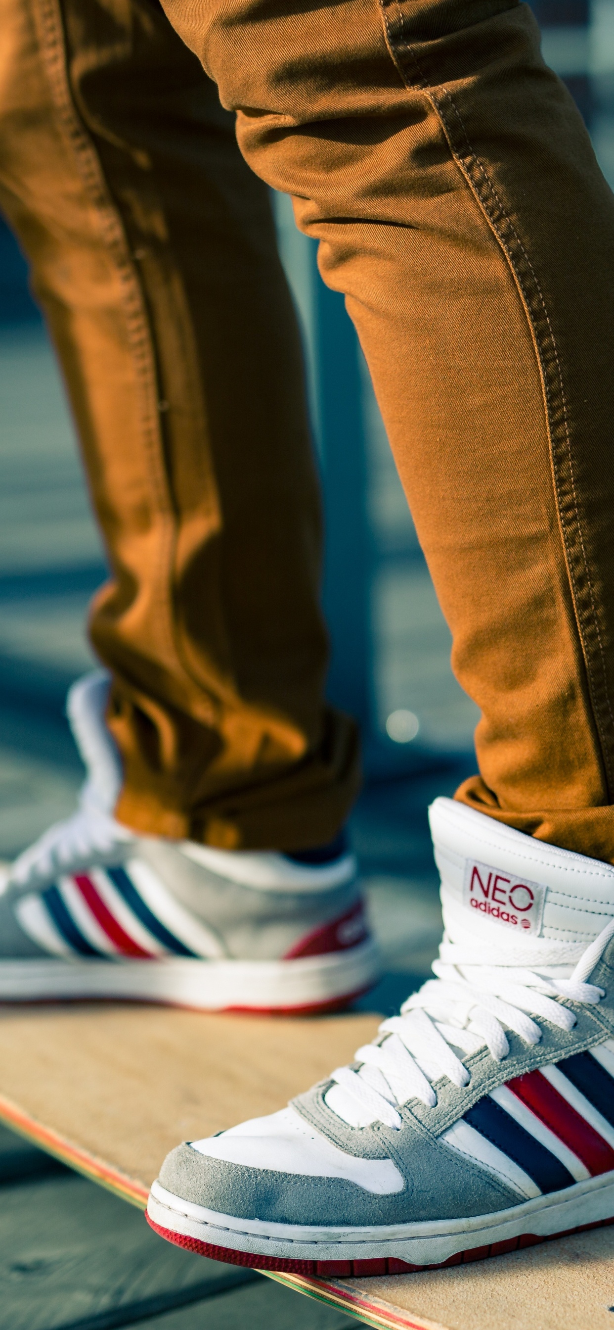 Person in Blue Denim Jeans Wearing White Red and Black Nike Sneakers. Wallpaper in 1242x2688 Resolution
