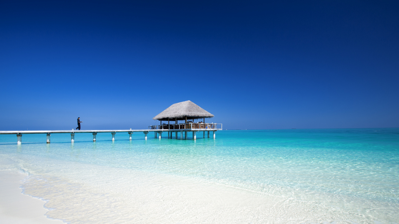 Maison de Plage en Bois Brun Sur la Plage de Sable Blanc Pendant la Journée. Wallpaper in 1280x720 Resolution