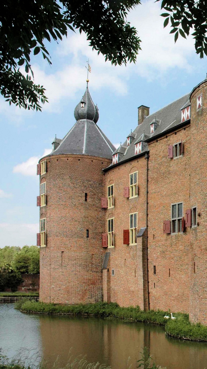 Brown Brick Building Near Green Trees and River During Daytime. Wallpaper in 720x1280 Resolution