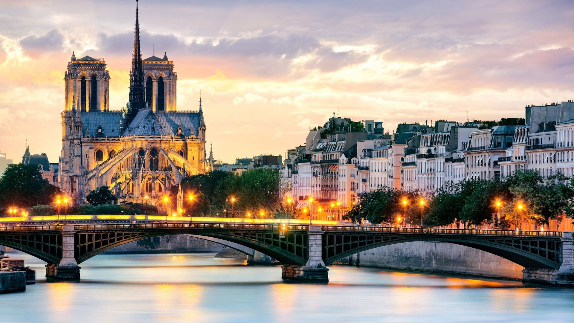 Bridge Over River Near City Buildings During Night Time. Wallpaper in 1920x1080 Resolution