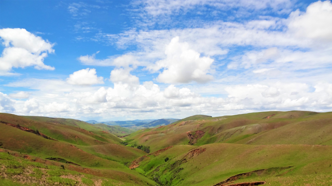 Montañas Verdes Bajo un Cielo Azul y Nubes Blancas Durante el Día. Wallpaper in 1366x768 Resolution