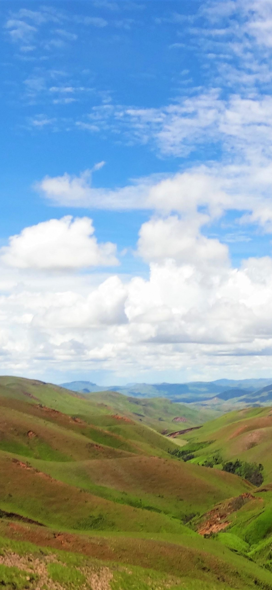 Green Mountains Under Blue Sky and White Clouds During Daytime. Wallpaper in 1125x2436 Resolution