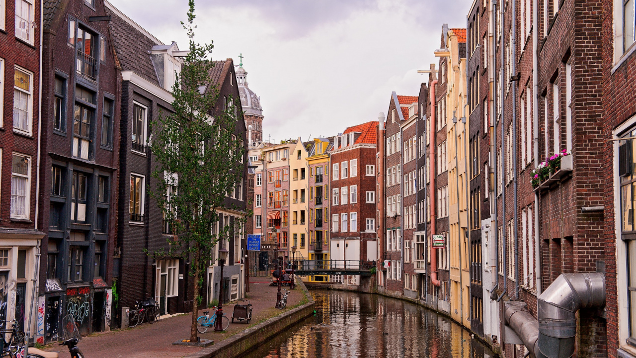 Edificios de Hormigón Marrón y Beige Cerca Del Río Bajo un Cielo Azul Durante el Día. Wallpaper in 1280x720 Resolution