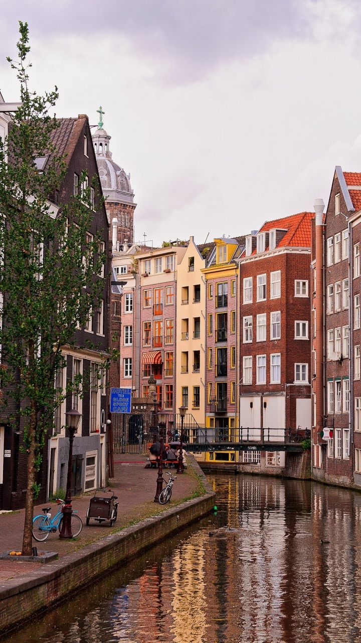 Brown and Beige Concrete Buildings Near River Under Blue Sky During Daytime. Wallpaper in 720x1280 Resolution