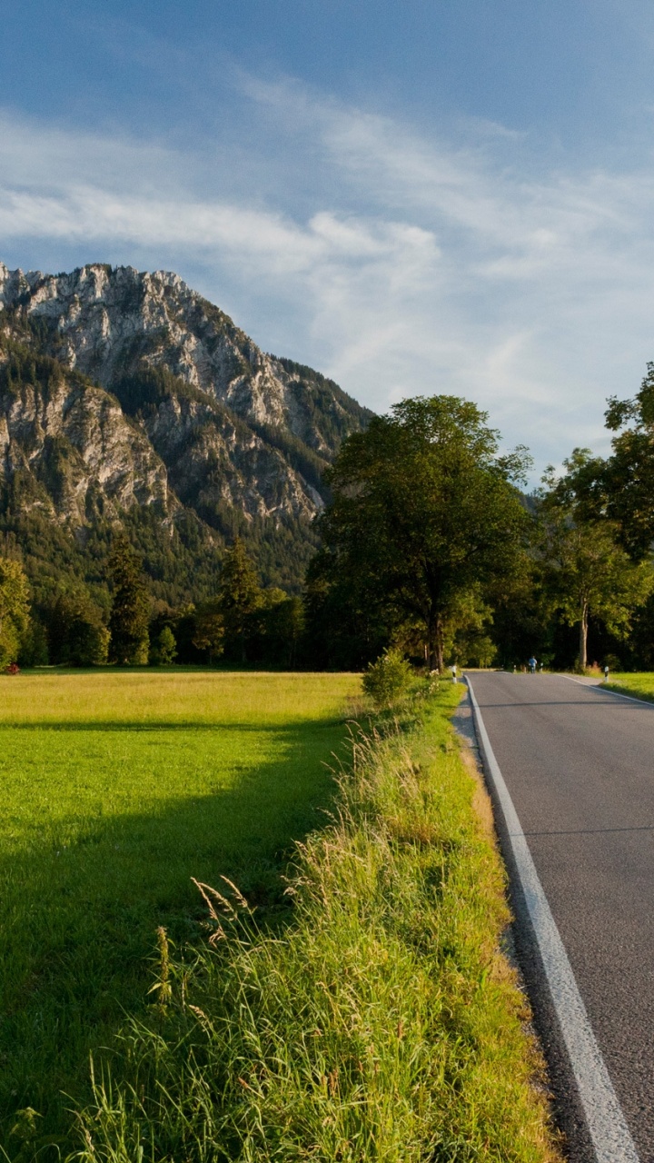 Grünes Grasfeld in Der Nähe Der Grauen Betonstraße Tagsüber Concrete. Wallpaper in 720x1280 Resolution