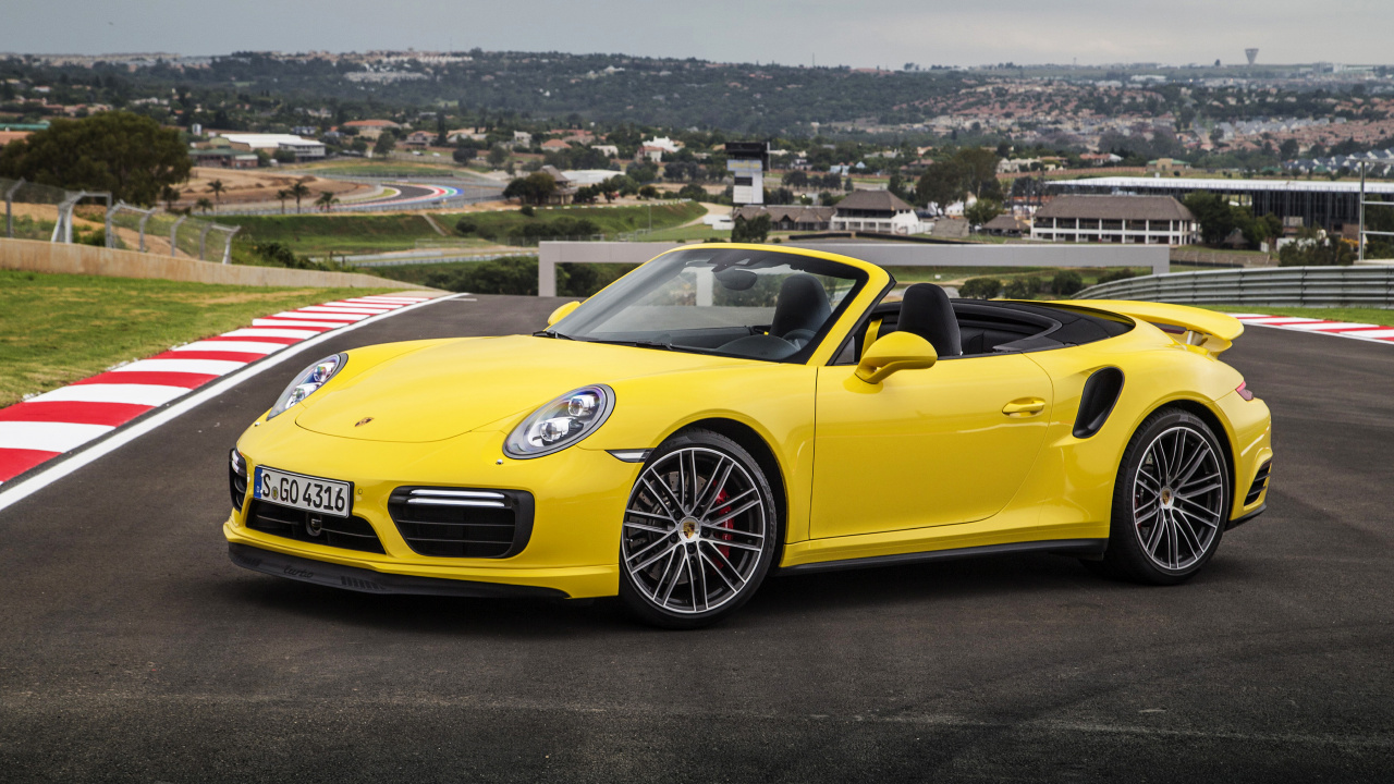 Gelber Porsche 911 Auf Einem Hügel Mit Blick Auf Stadtgebäude Tagsüber. Wallpaper in 1280x720 Resolution