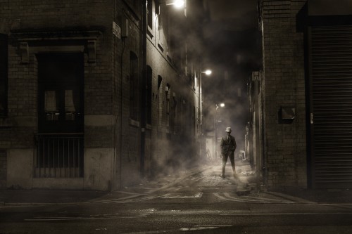 Image man in black jacket walking on street during night time