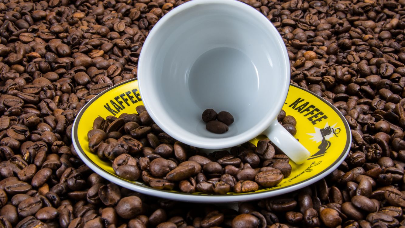 white ceramic mug on coffee beans