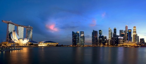 Image city skyline across body of water during night time