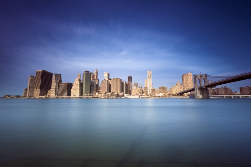 Image city skyline across body of water during daytime