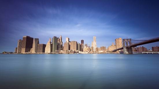 Image city skyline across body of water during daytime