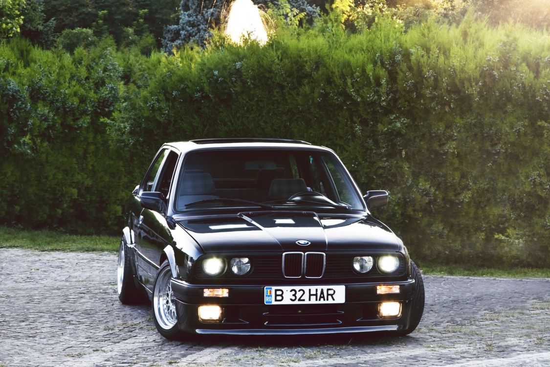 black bmw m 3 parked on gray dirt road during daytime