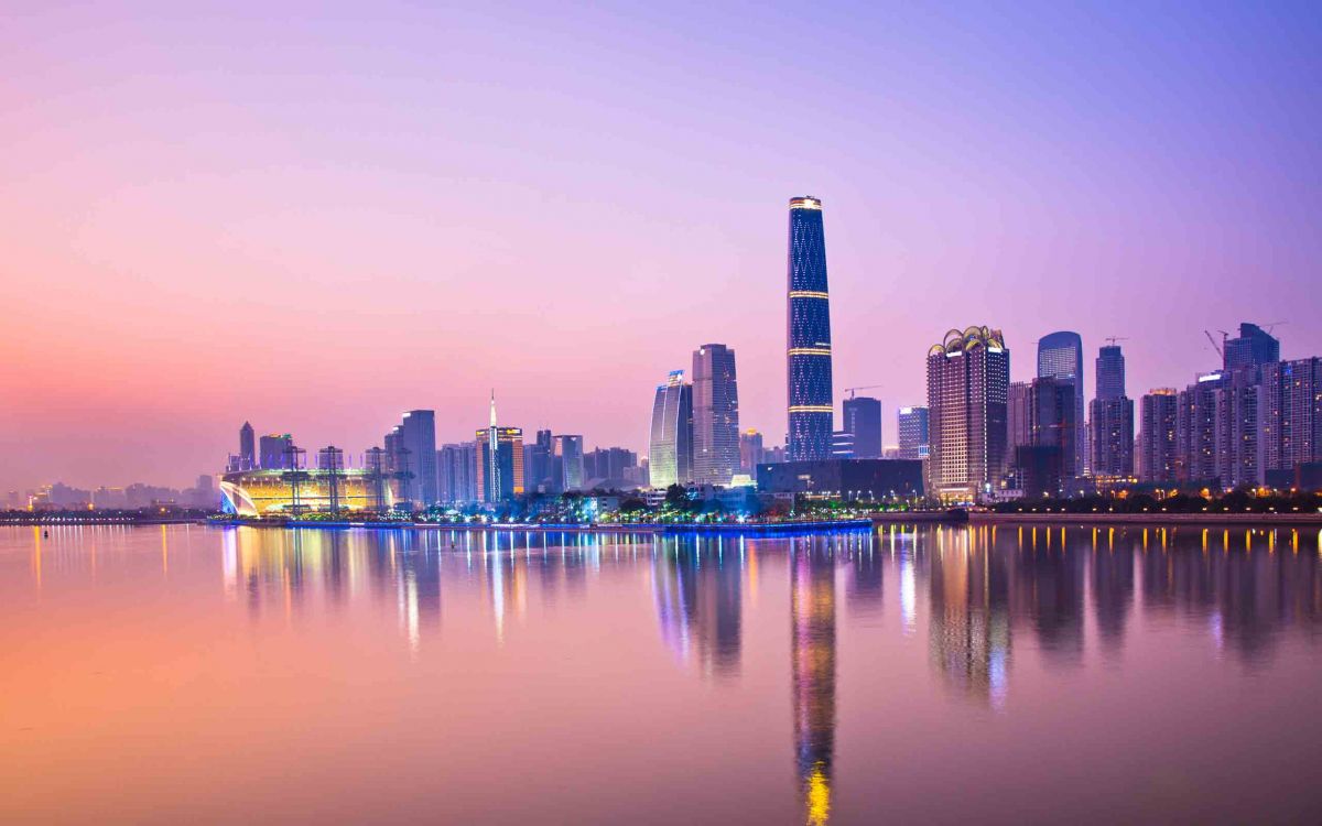 city skyline across body of water during night time