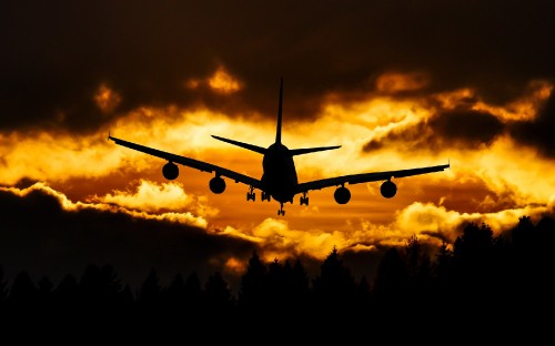 Image airplane flying over the clouds during sunset