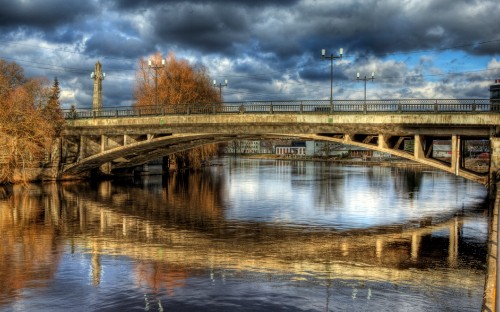 Image brown concrete bridge over river under cloudy sky during daytime