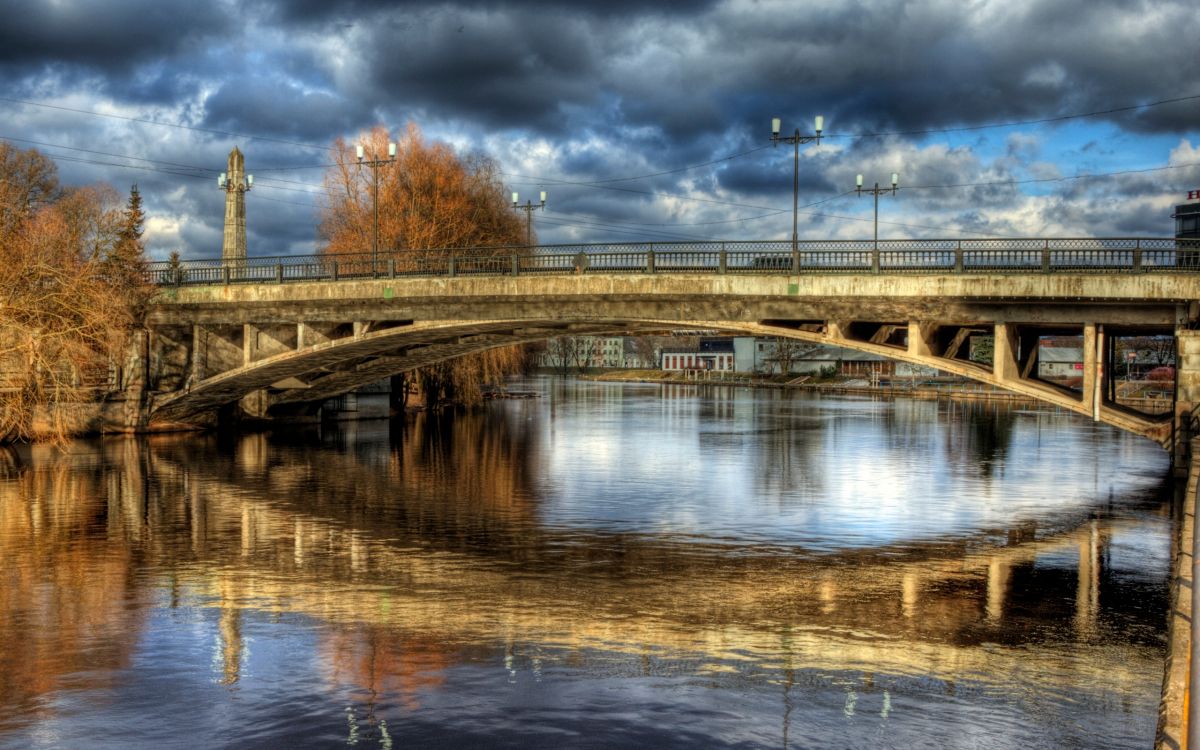 Brown Concrete Bridge Over River Under Cloudy Sky During Daytime. Wallpaper in 2560x1600 Resolution