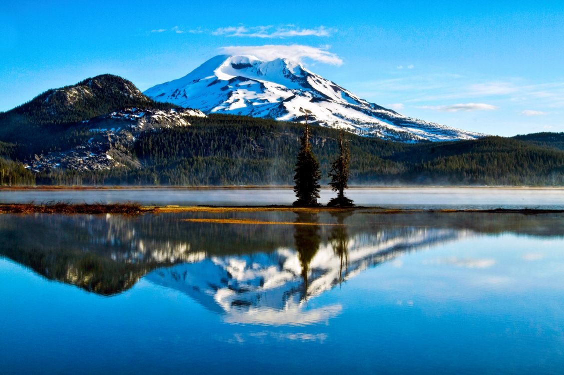 snow covered mountain near lake during daytime