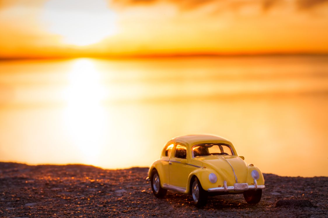 Volkswagen Beetle Amarillo en la Orilla Durante la Puesta de Sol. Wallpaper in 5616x3744 Resolution