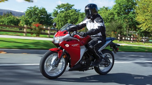 Image man in white jacket riding red sports bike on road during daytime