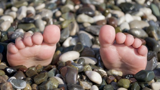 Image person holding gray and white pebbles