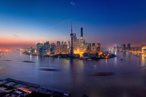 Image city skyline across body of water during night time