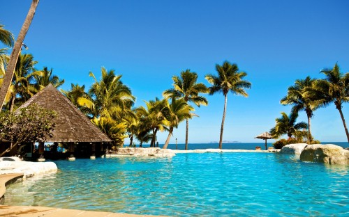 Image brown wooden beach house near palm trees during daytime