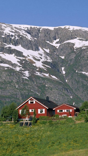 Image red and white house near snow covered mountain during daytime