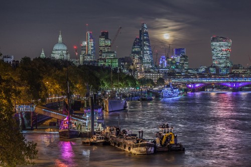 Image boat on dock near city buildings during night time