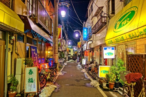 Image empty street with cars parked beside buildings during night time