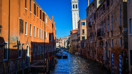 Image river between brown concrete buildings during daytime