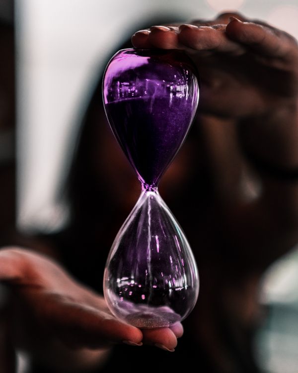 purple hour glass on persons hand