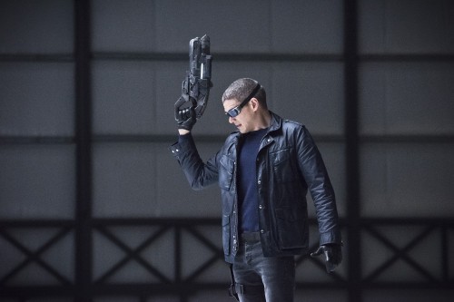 Image man in blue jacket holding black rifle