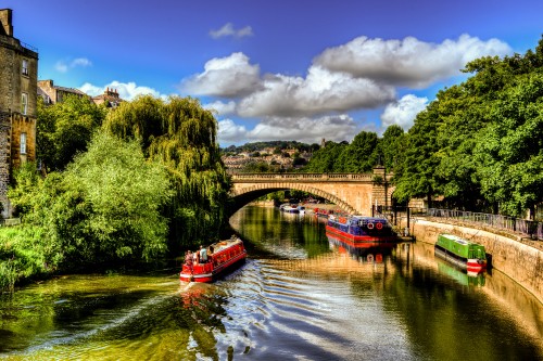 Image red boat on river near green trees under blue sky and white clouds during daytime