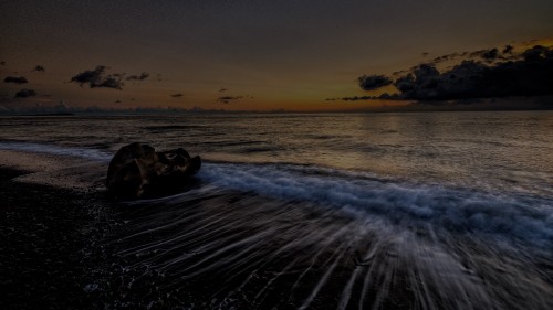 Image ocean waves crashing on shore during sunset