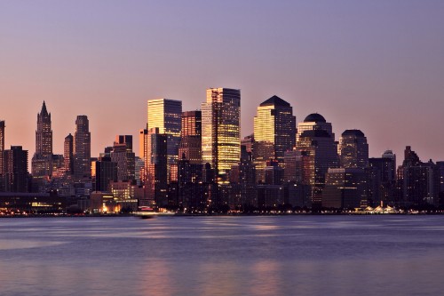 Image city skyline across body of water during night time