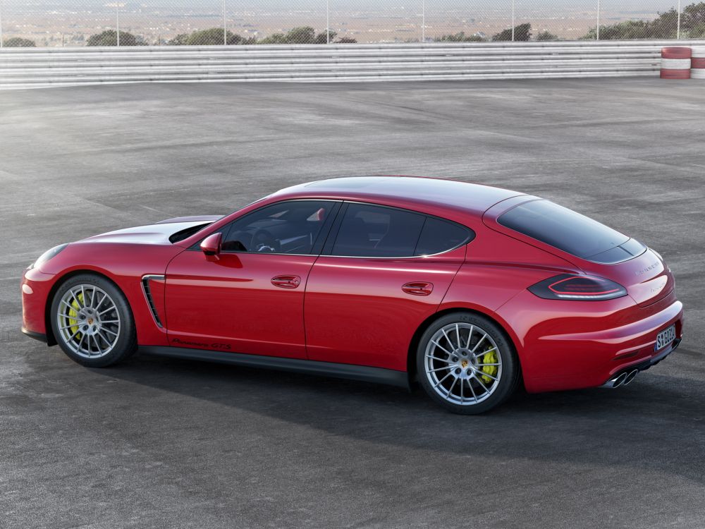 red coupe on gray asphalt road during daytime