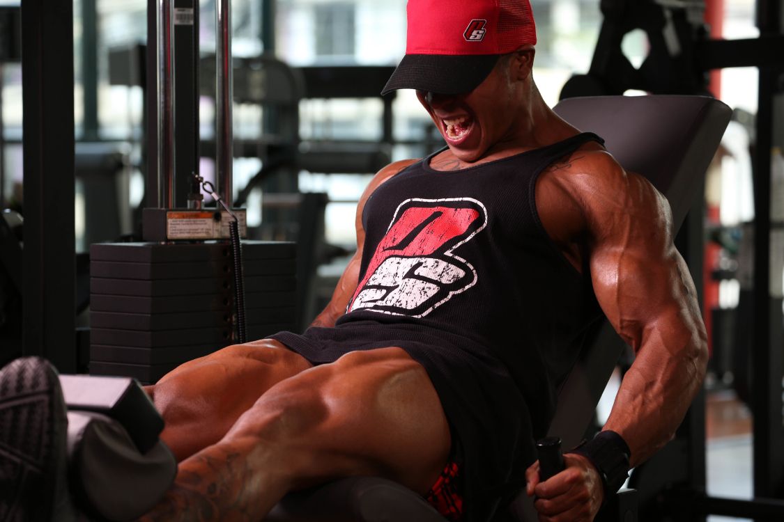 man in black tank top and red fitted cap