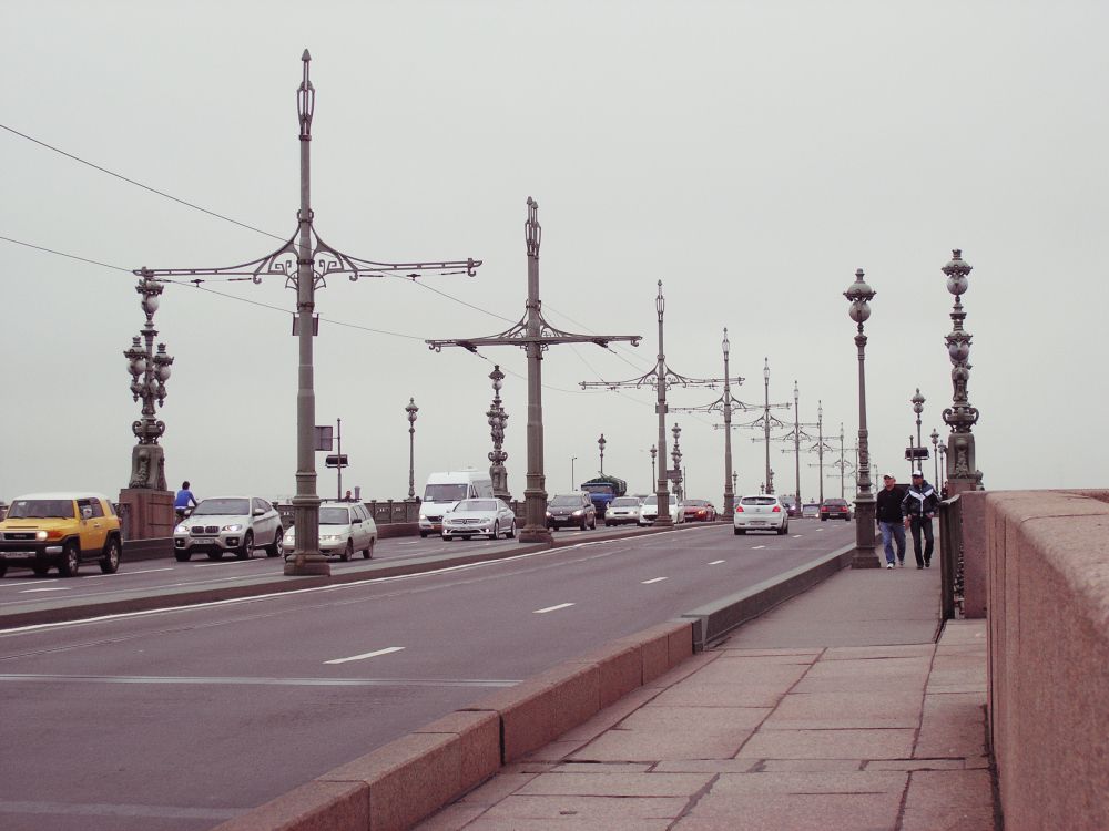 people walking on sidewalk near street light posts during daytime