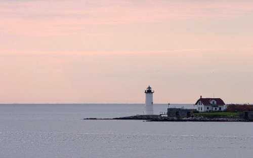 Image white and black lighthouse on island during daytime