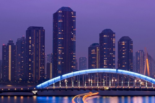 Image lighted bridge near high rise buildings during night time