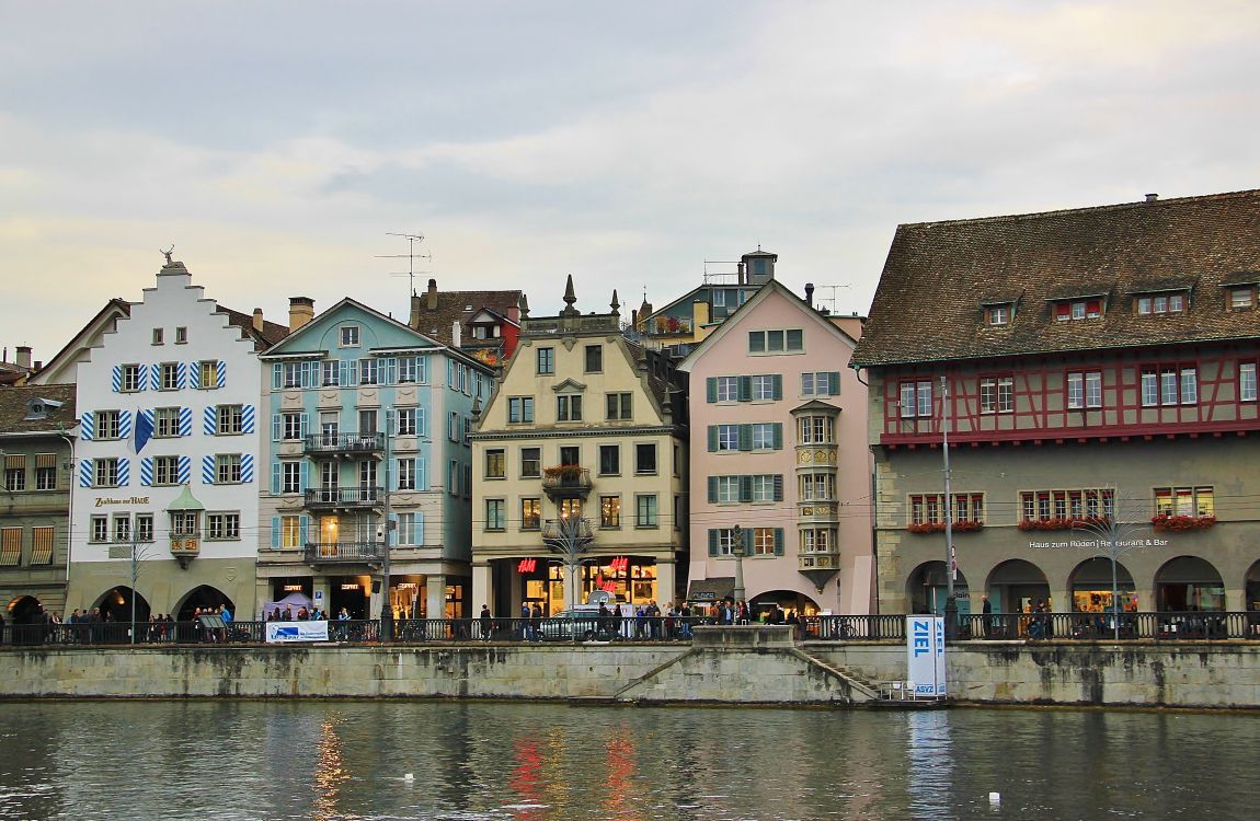 Braunes Und Weißes Betongebäude Neben Einem Gewässer Tagsüber. Wallpaper in 3389x2209 Resolution