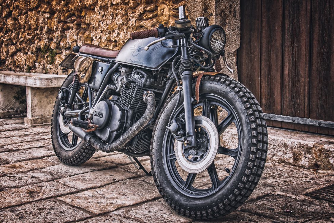 black and silver motorcycle near brown wooden wall