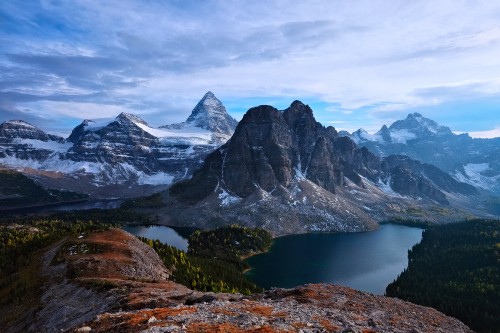 Image snow covered mountain near lake under cloudy sky during daytime