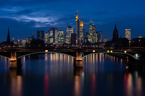 Image bridge over river near city buildings during night time