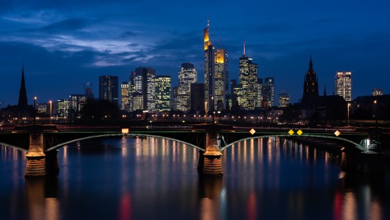 Image bridge over river near city buildings during night time