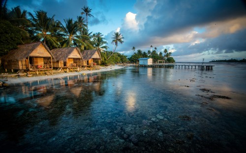 Image brown wooden house near body of water during daytime