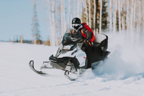 Image person riding black and white snow mobile